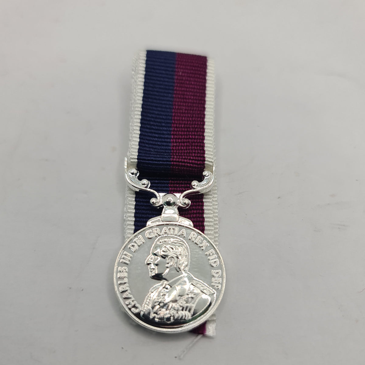 A miniature RAF medal with a King's head design, attached to a red and blue ribbon, displayed against a white background.